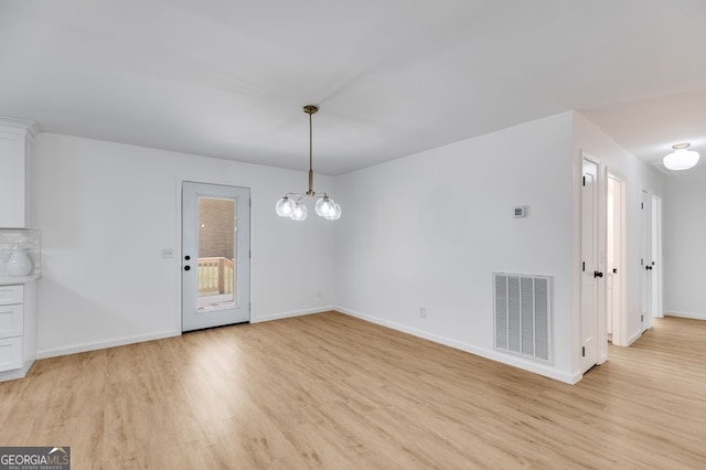 unfurnished dining area with light hardwood / wood-style flooring and an inviting chandelier