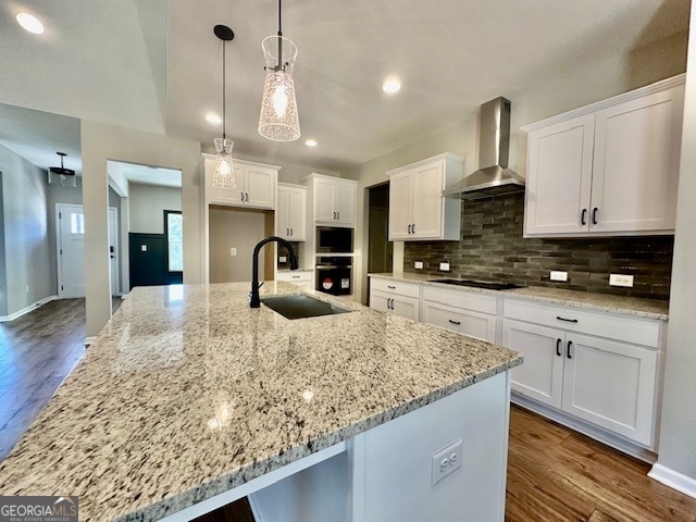 kitchen featuring a spacious island, wall chimney range hood, pendant lighting, white cabinetry, and dark hardwood / wood-style flooring