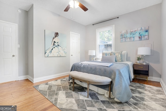 bedroom featuring a textured ceiling, ceiling fan, and hardwood / wood-style floors