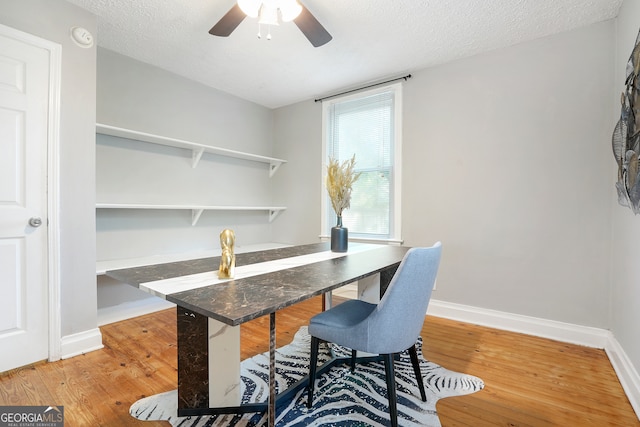 home office with wood-type flooring, ceiling fan, and a textured ceiling