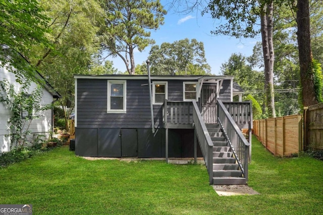 back of house featuring a wooden deck, a lawn, and central AC unit