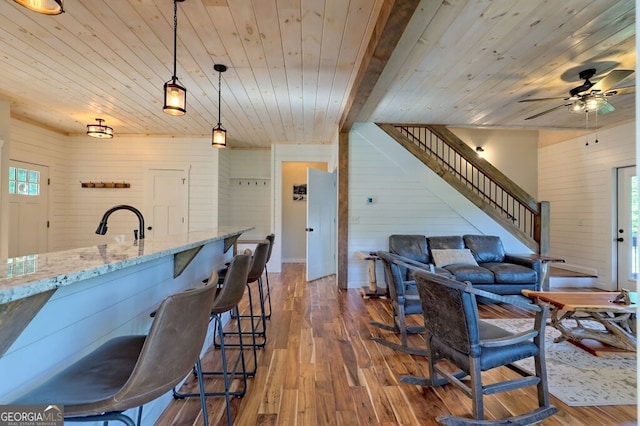 dining area with wood walls, dark hardwood / wood-style floors, wood ceiling, and ceiling fan