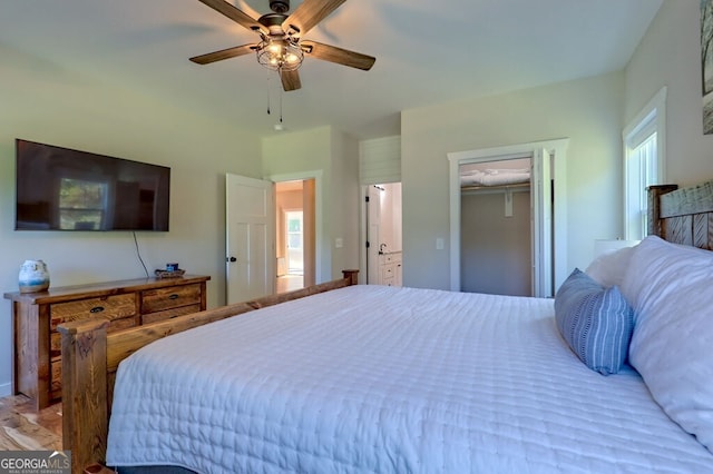 bedroom featuring a spacious closet, light wood-type flooring, a closet, and ceiling fan