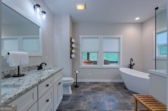 bathroom featuring vanity, plenty of natural light, tile patterned flooring, and toilet