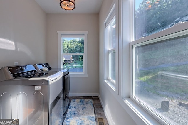 washroom featuring washing machine and dryer, laundry area, visible vents, and baseboards