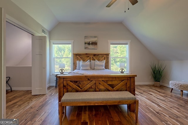 bedroom featuring lofted ceiling, wood finished floors, visible vents, and baseboards