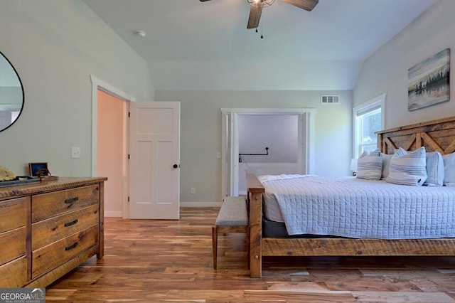 bedroom featuring baseboards, visible vents, a ceiling fan, lofted ceiling, and wood finished floors