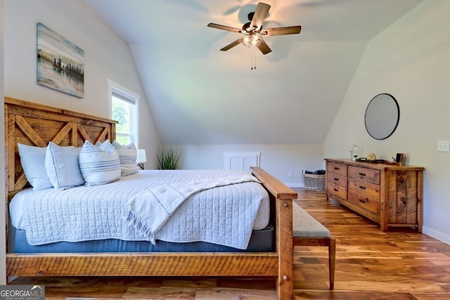 bedroom with baseboards, a ceiling fan, vaulted ceiling, and wood finished floors