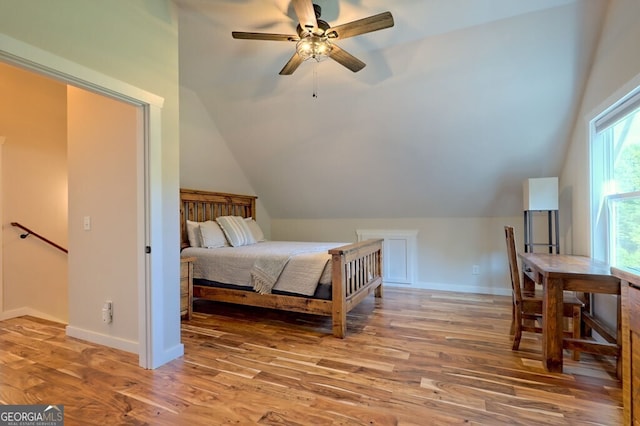 bedroom featuring a ceiling fan, lofted ceiling, baseboards, and wood finished floors