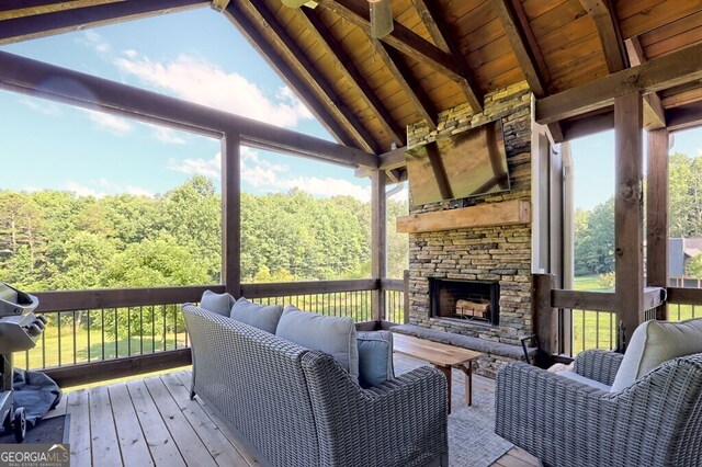 wooden terrace with an outdoor living space with a fireplace