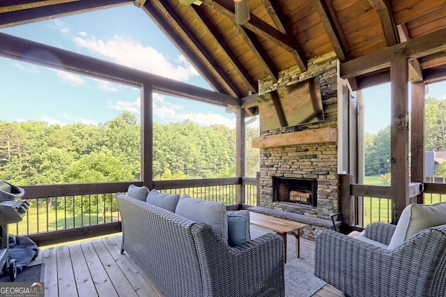 wooden terrace with an outdoor stone fireplace