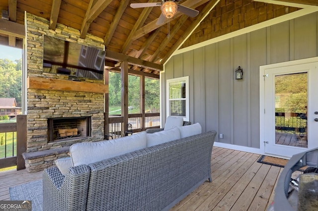 wooden terrace featuring ceiling fan and an outdoor living space with a fireplace