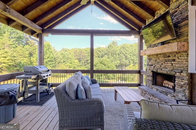 wooden terrace featuring grilling area and an outdoor living space with a fireplace