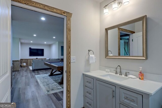 bathroom featuring recessed lighting, wood finished floors, billiards, vanity, and wainscoting