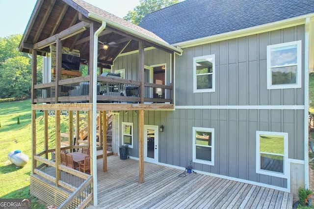 back of house with ceiling fan, a shingled roof, board and batten siding, and a wooden deck