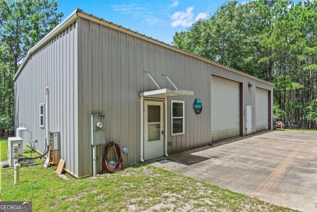 view of front of home with a garage and an outbuilding