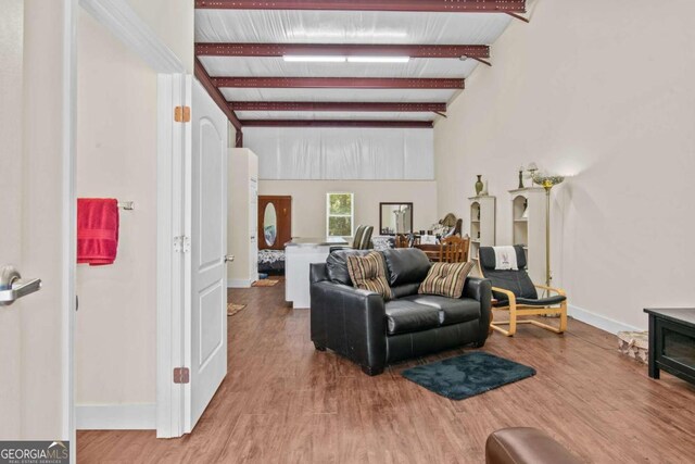 living room featuring hardwood / wood-style floors and beamed ceiling