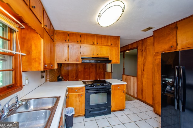 kitchen featuring black appliances, sink, and light tile patterned floors