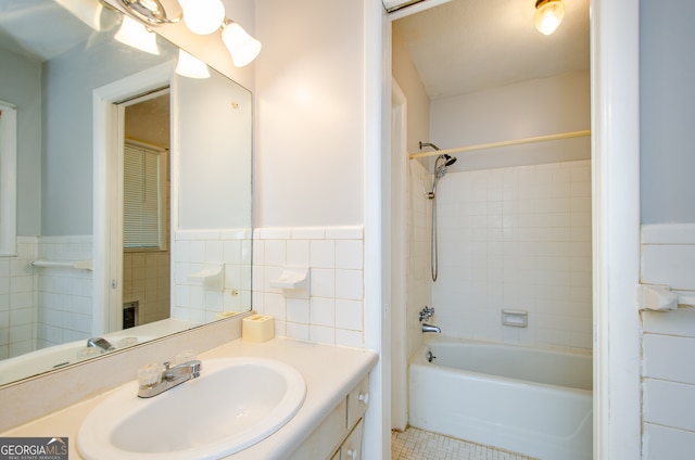 bathroom with decorative backsplash, tile walls, tiled shower / bath, tile patterned floors, and vanity