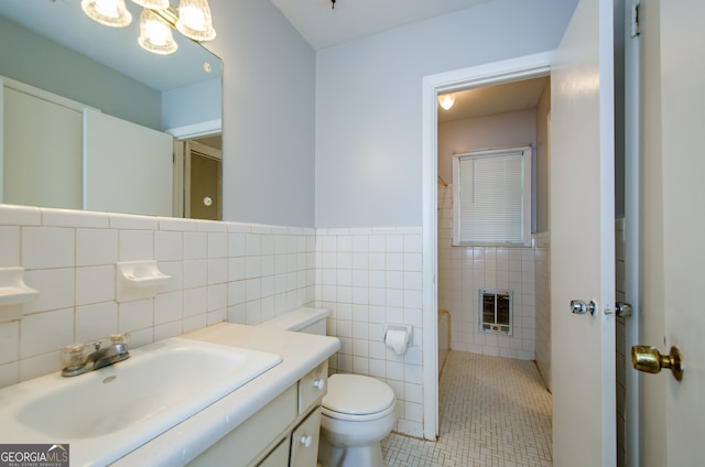 bathroom featuring toilet, tile walls, tasteful backsplash, tile patterned floors, and vanity