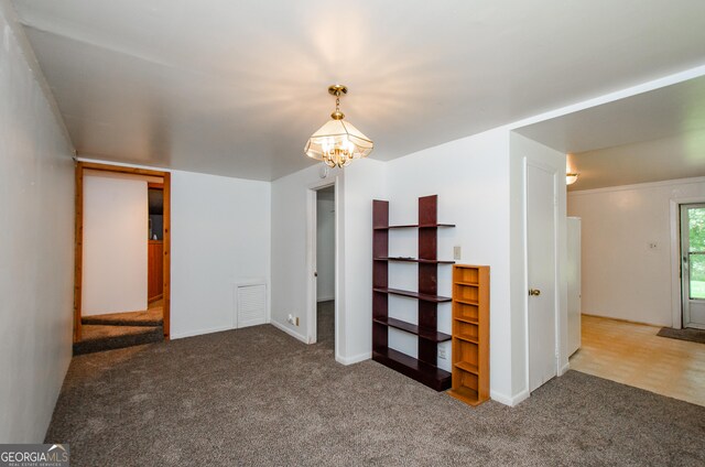 empty room featuring a chandelier and carpet