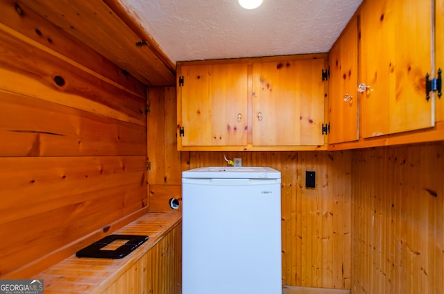 laundry room featuring cabinets, a textured ceiling, and hookup for a washing machine