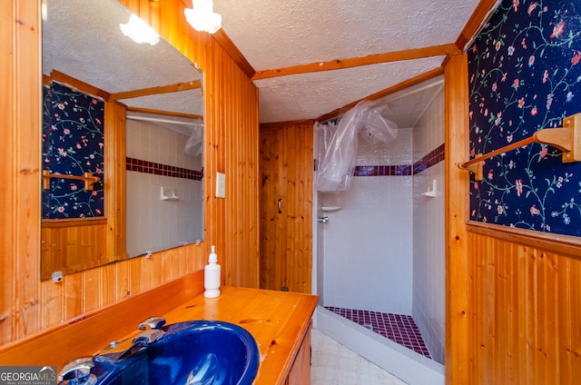 bathroom featuring a tile shower, a textured ceiling, tile patterned flooring, and vanity