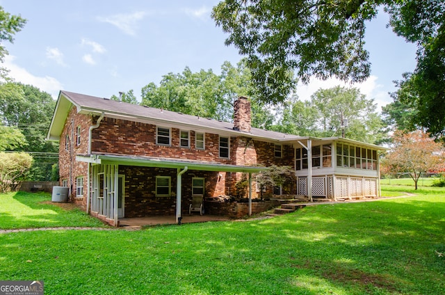 rear view of house with central AC, a lawn, a sunroom, and a patio area