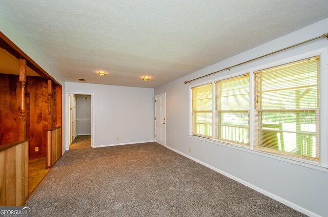 carpeted empty room featuring a textured ceiling