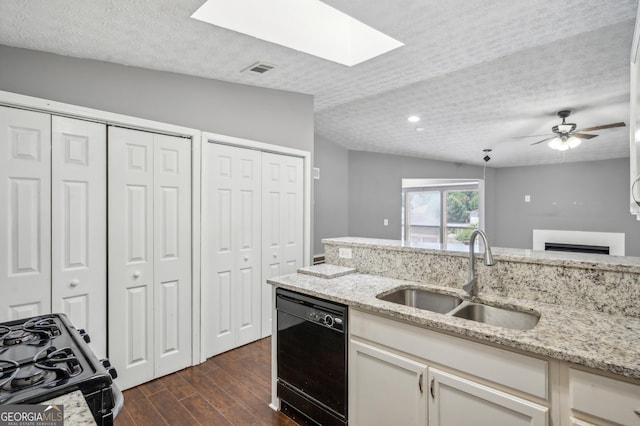 kitchen with visible vents, dark wood-type flooring, a sink, light stone countertops, and black appliances