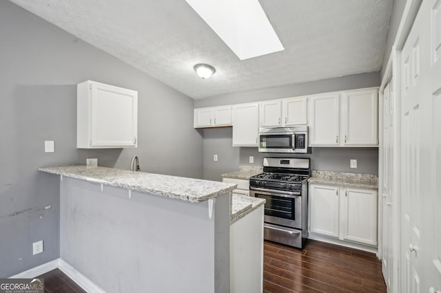 kitchen featuring stainless steel appliances, dark wood-style flooring, and white cabinetry