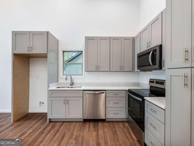 kitchen featuring dark hardwood / wood-style flooring, sink, gray cabinetry, and stainless steel appliances