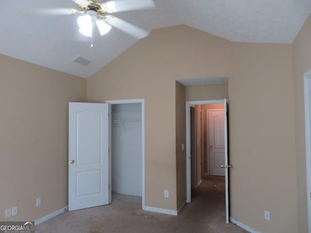 unfurnished bedroom featuring light carpet, vaulted ceiling, and a closet