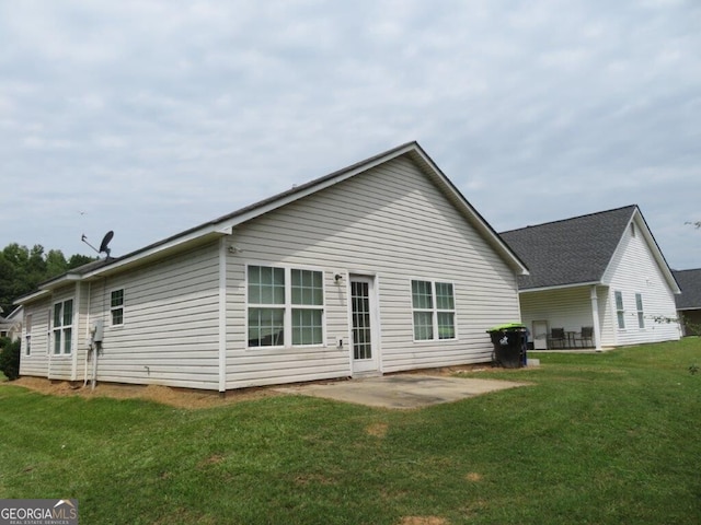 back of property with a yard and a patio