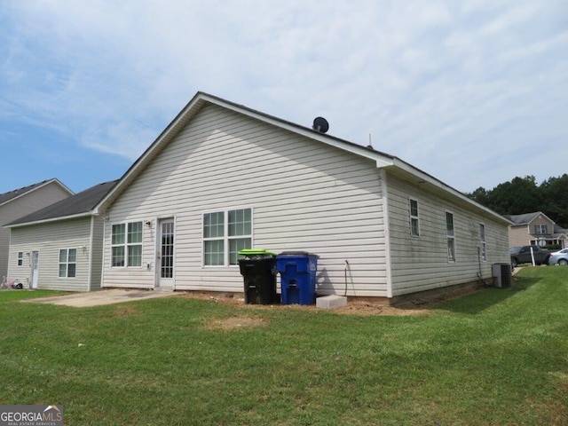 rear view of house featuring central AC, a yard, and a patio area