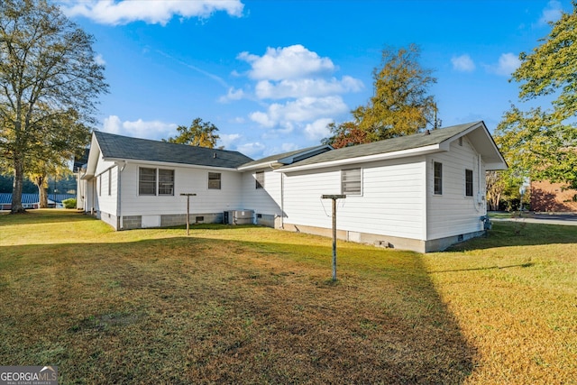 rear view of house with a yard and cooling unit