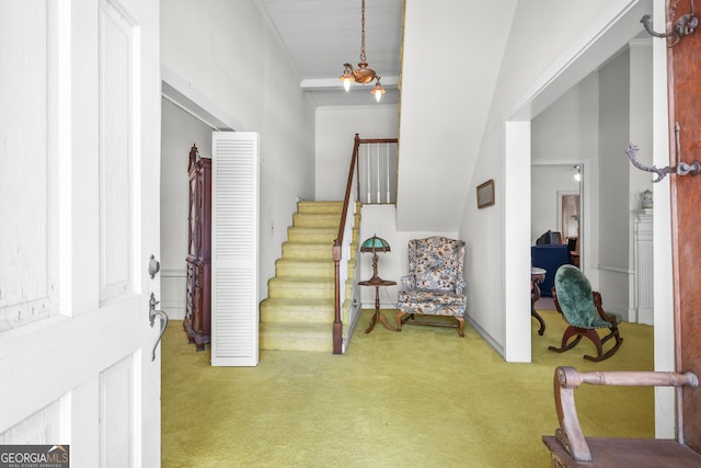 carpeted entryway with a chandelier and vaulted ceiling