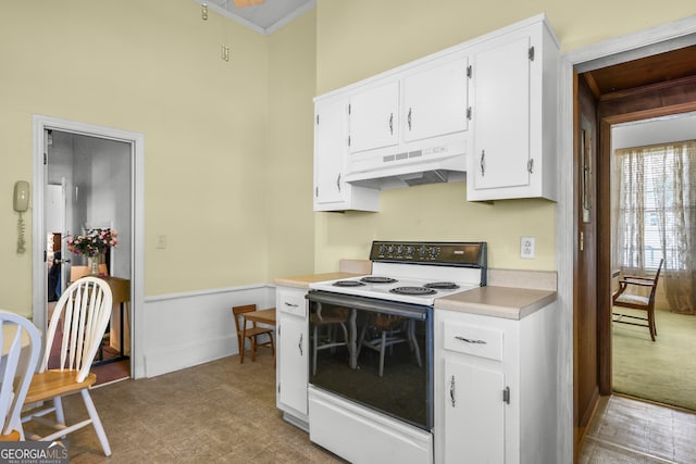 kitchen with crown molding, white cabinets, and white electric range