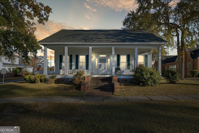 bungalow-style home featuring a porch and a lawn