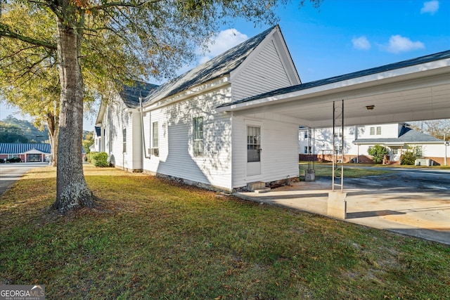 view of home's exterior with a carport and a lawn