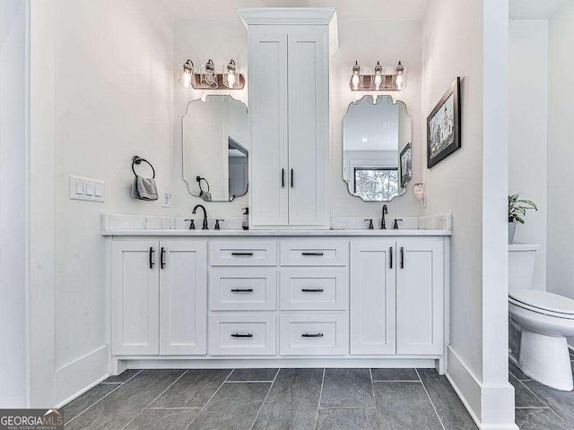 bathroom with double vanity, toilet, and tile patterned flooring