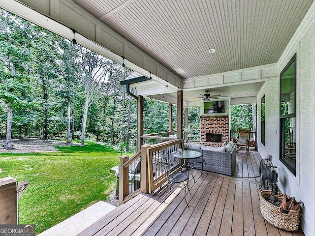 deck featuring ceiling fan and a yard