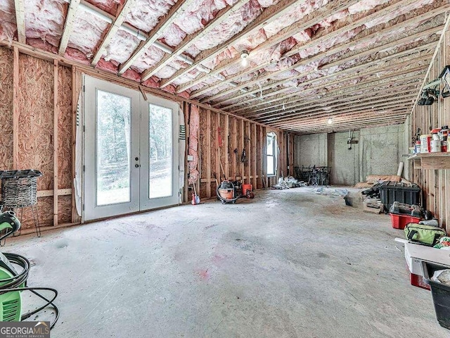 miscellaneous room with french doors, a healthy amount of sunlight, and concrete floors