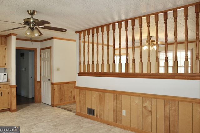 interior space featuring ceiling fan and ornamental molding