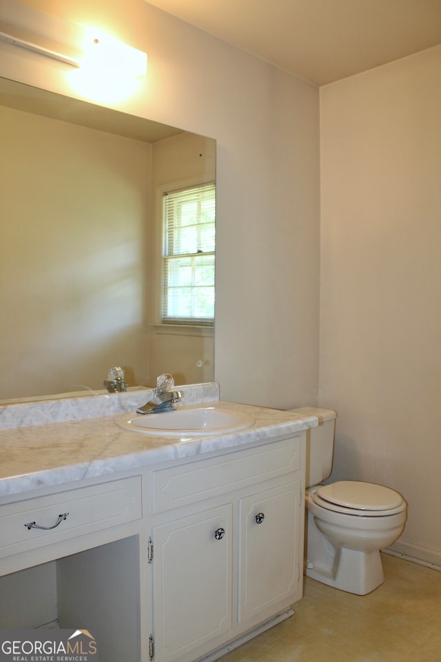 bathroom featuring tile patterned flooring, vanity, and toilet