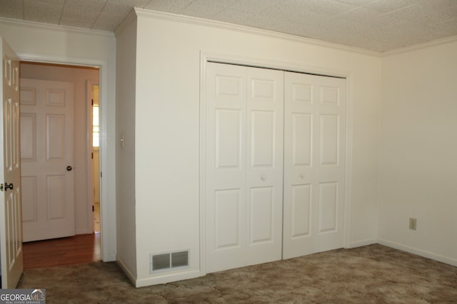 unfurnished bedroom featuring a closet, carpet, and crown molding