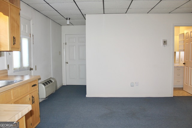 kitchen featuring a paneled ceiling and carpet