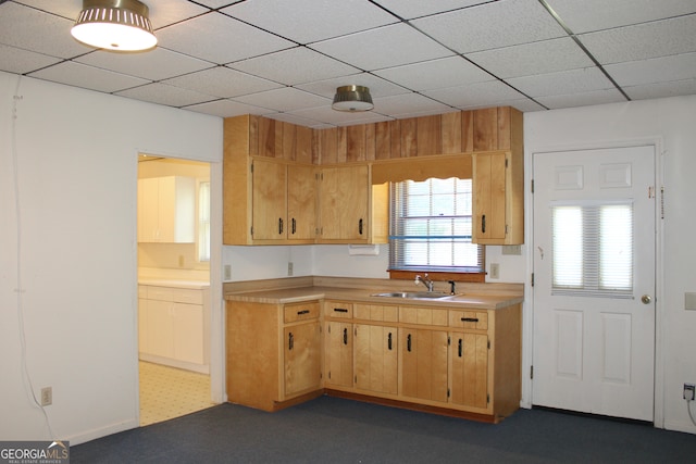 kitchen with dark tile patterned flooring, sink, and a paneled ceiling