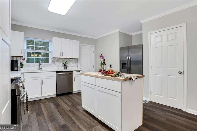 kitchen featuring white cabinets, appliances with stainless steel finishes, sink, and a kitchen island