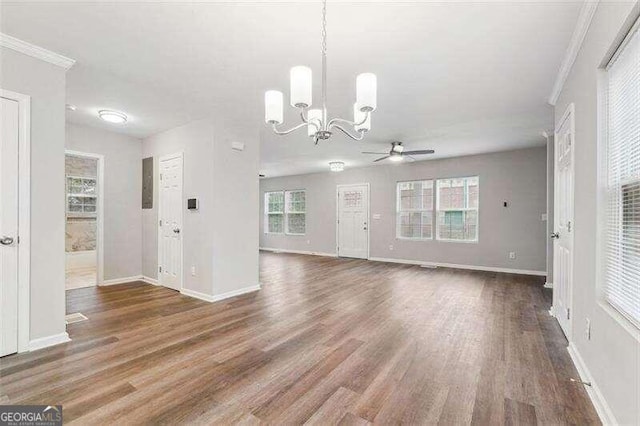 unfurnished living room featuring ceiling fan with notable chandelier, electric panel, crown molding, and dark hardwood / wood-style floors